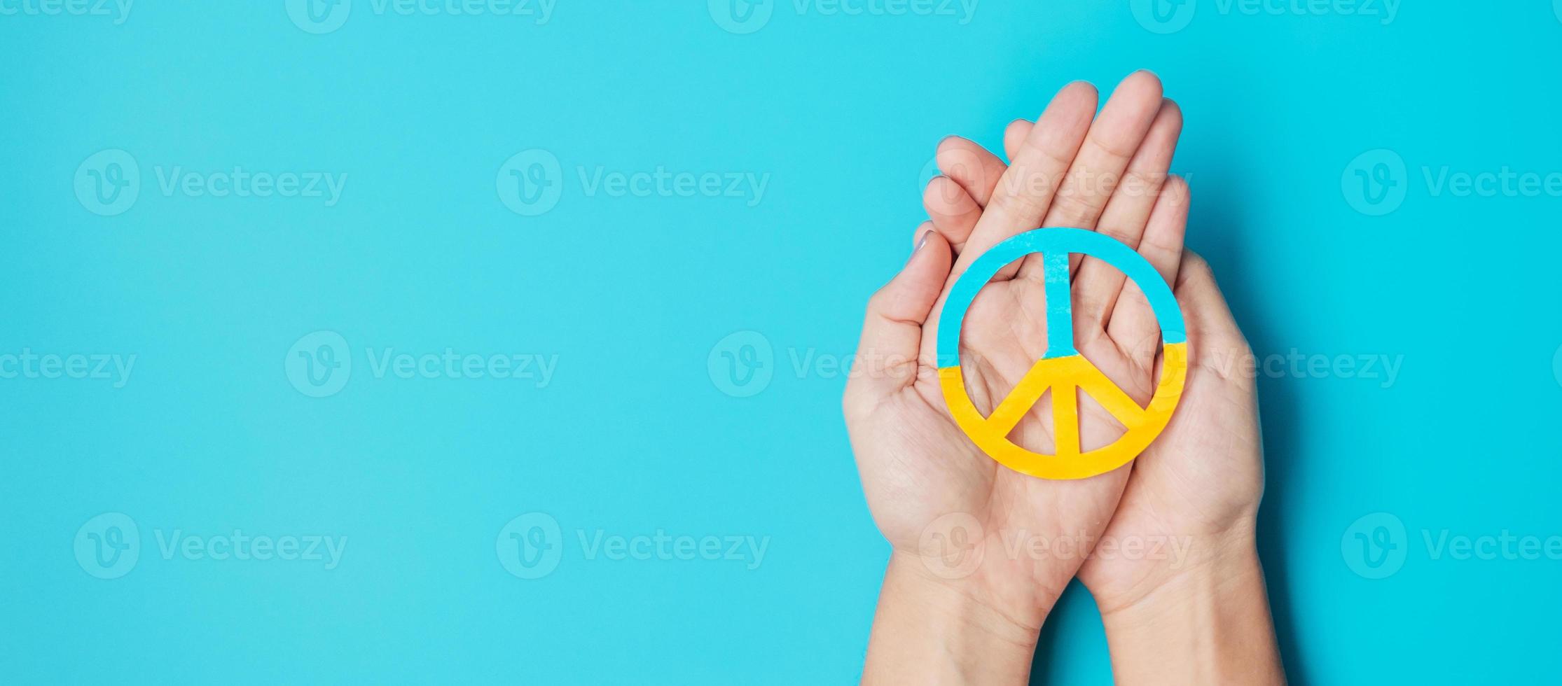 Support for Ukraine in the war with Russia, Hands holding symbol of peace with flag of Ukraine. Pray, No war, stop war, stand with Ukraine and Nuclear Disarmament photo