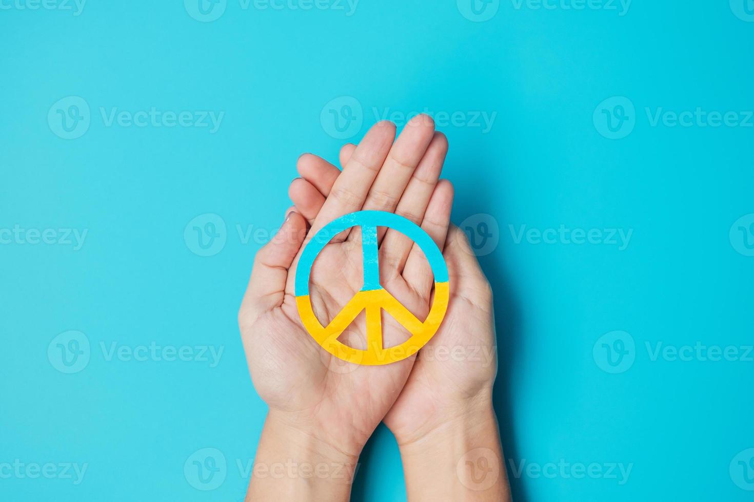 Support for Ukraine in the war with Russia, Hands holding symbol of peace with flag of Ukraine. Pray, No war, stop war, stand with Ukraine and Nuclear Disarmament photo