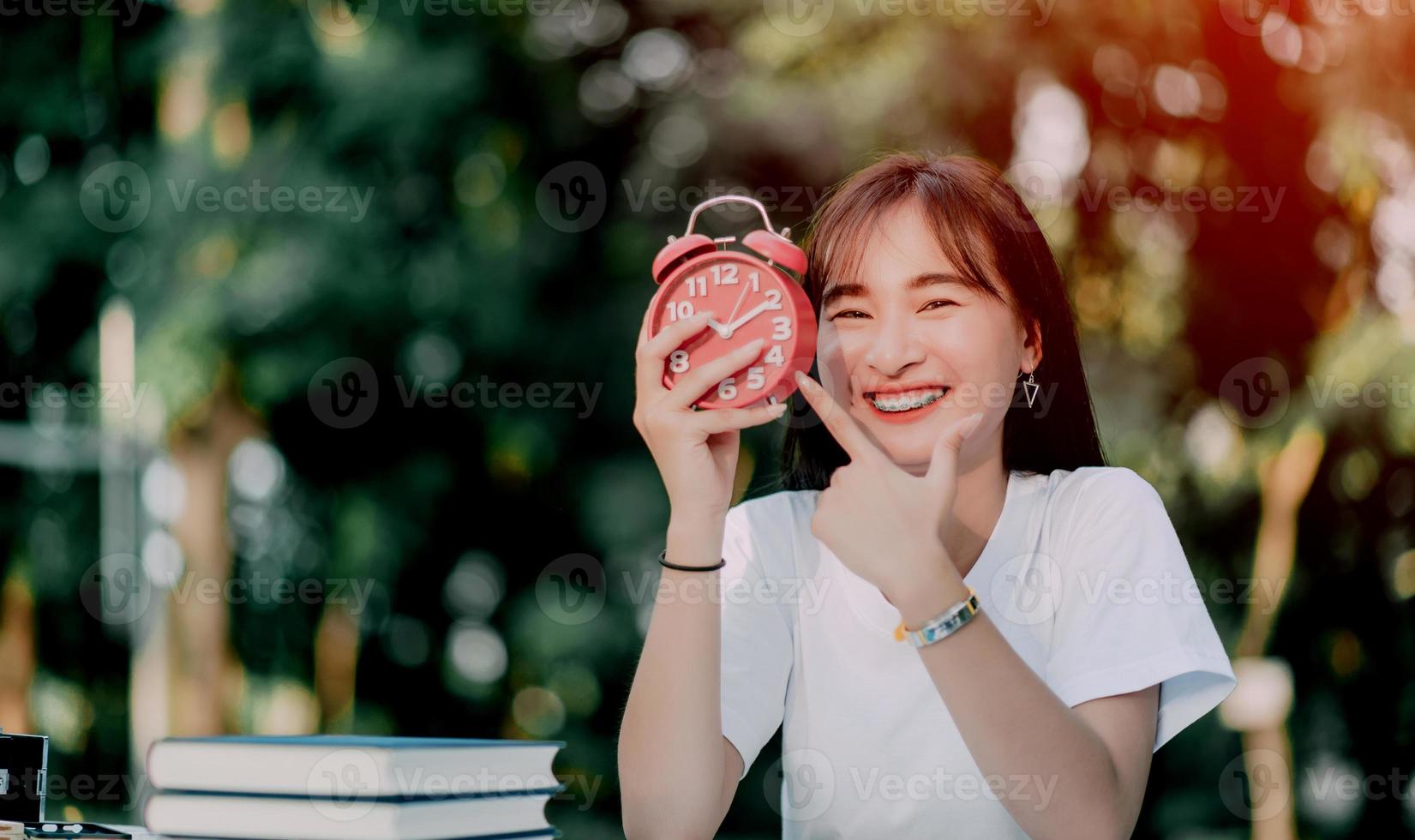 red alarm clock time management concept Female hands adjust or change the time on the clock to work. photo