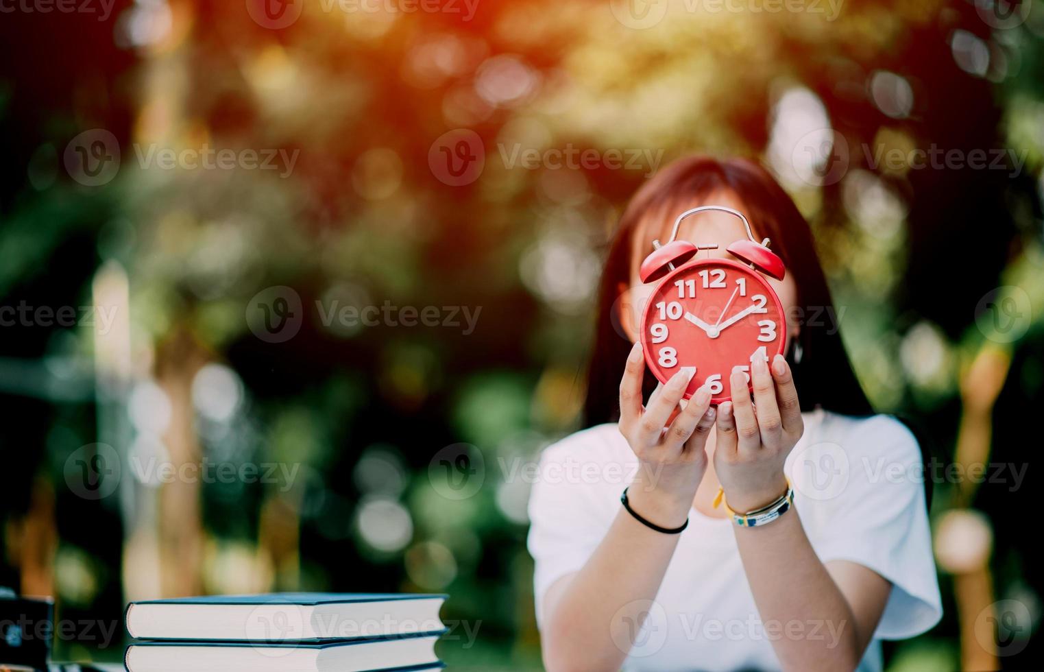 red alarm clock time management concept Female hands adjust or change the time on the clock to work. photo