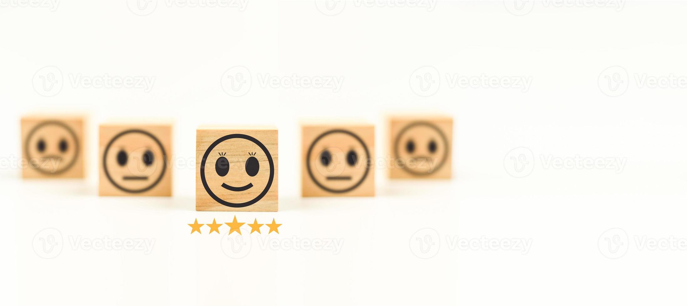 This Feedback with smile face wood cube happy smiley face icon to give satisfaction in service. rating very impressed. Black, Customer service and Satisfaction concept. Copy space, Selective focus. photo