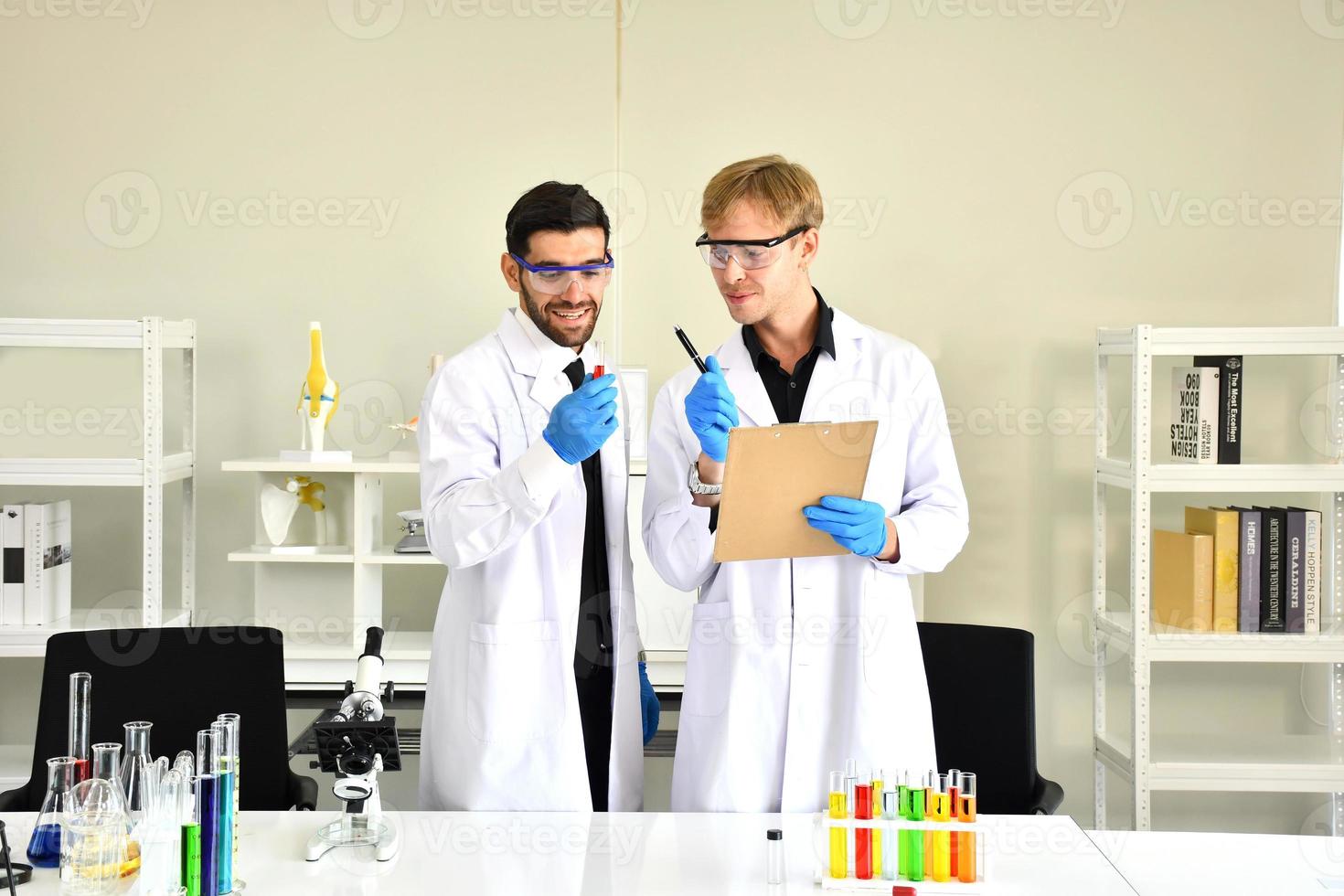 prueba de aceite lubricante de la industria química en concepto de laboratorio. los dos profesionales de la química científica analizan muestras de combustible de gasolina de petróleo en un laboratorio químico. foto