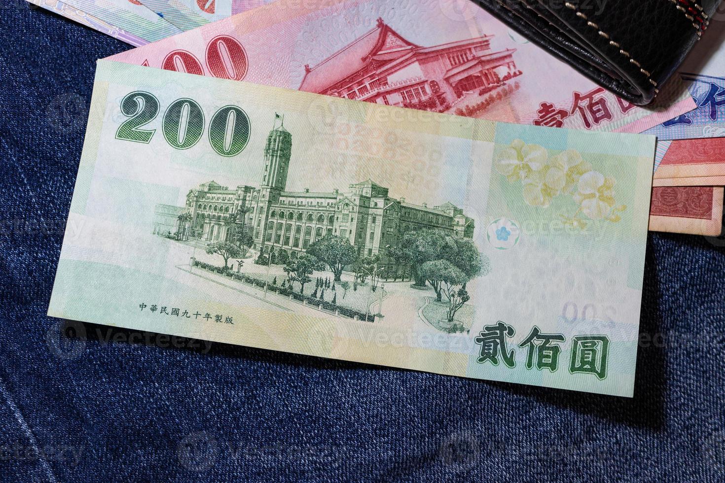 dinero taiwanés, billete de taiwán, dólar de taiwán sobre fondo de jean. foto