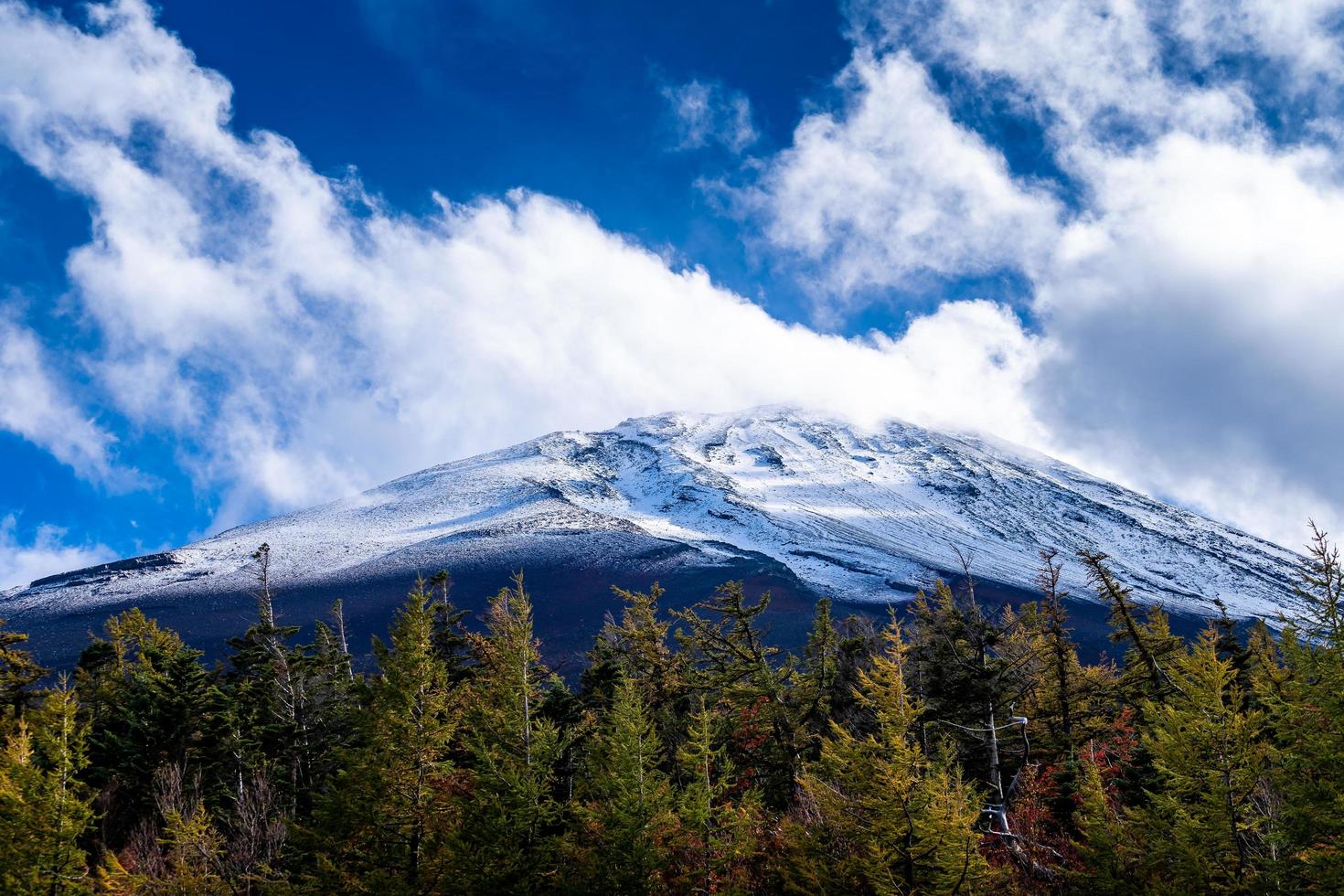 cierra la cima de la montaña fuji con cubierta de nieve y viento en la cima con podría en japón. foto