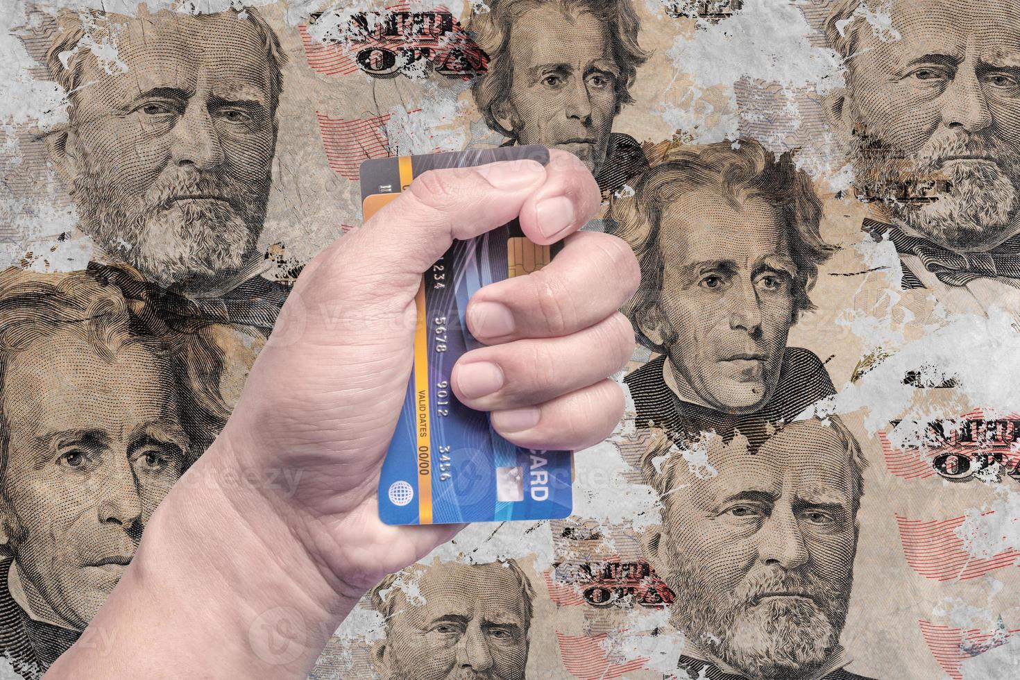 Credit card in the hand of a man with a picture of the dollar money on an old wall. photo