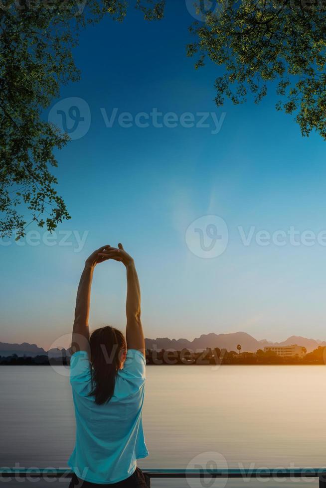 Woman is relax standing after run with a view of the river in the morning. photo