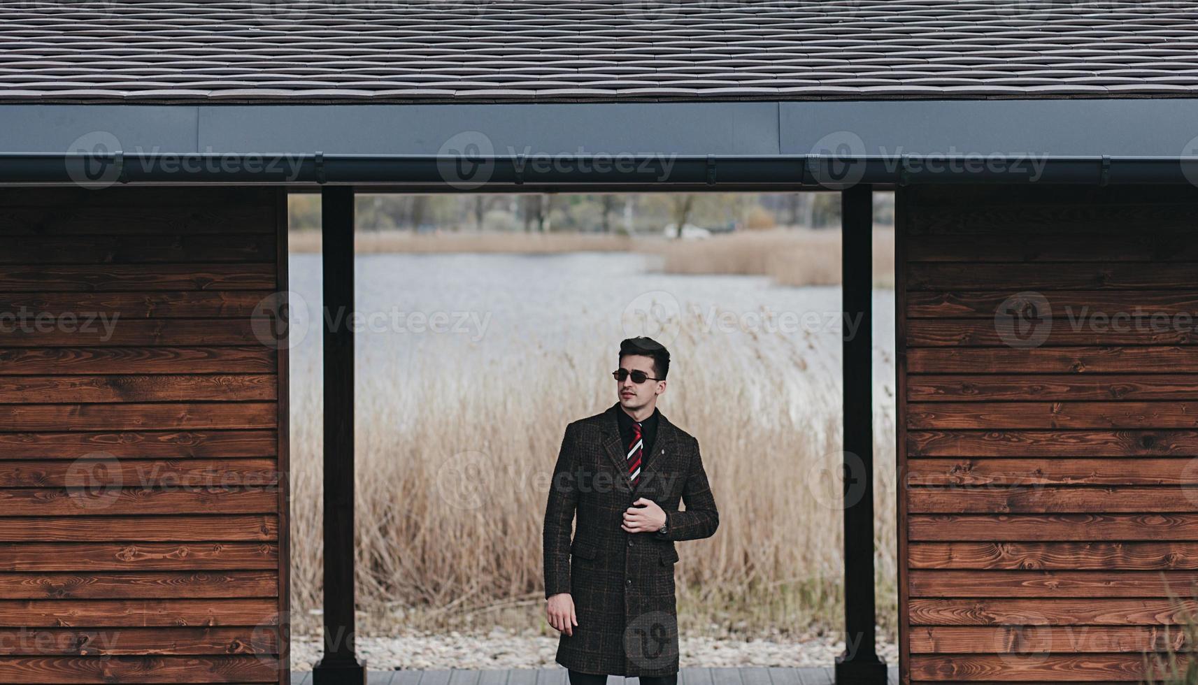 man in trendy eyeglasses and coat photo