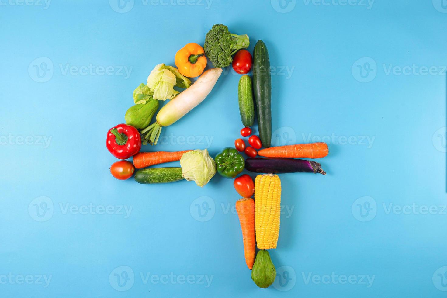 Healthy Organic Vegetables Shaped in Number Four 4 on Blue Background photo