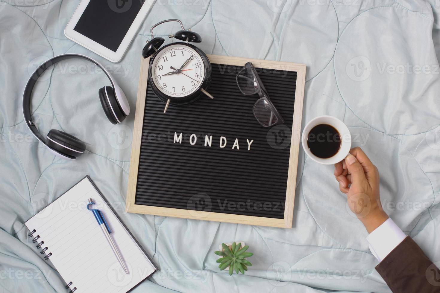 Monday flat lay business concept with businessman hand holding a cup of coffee photo