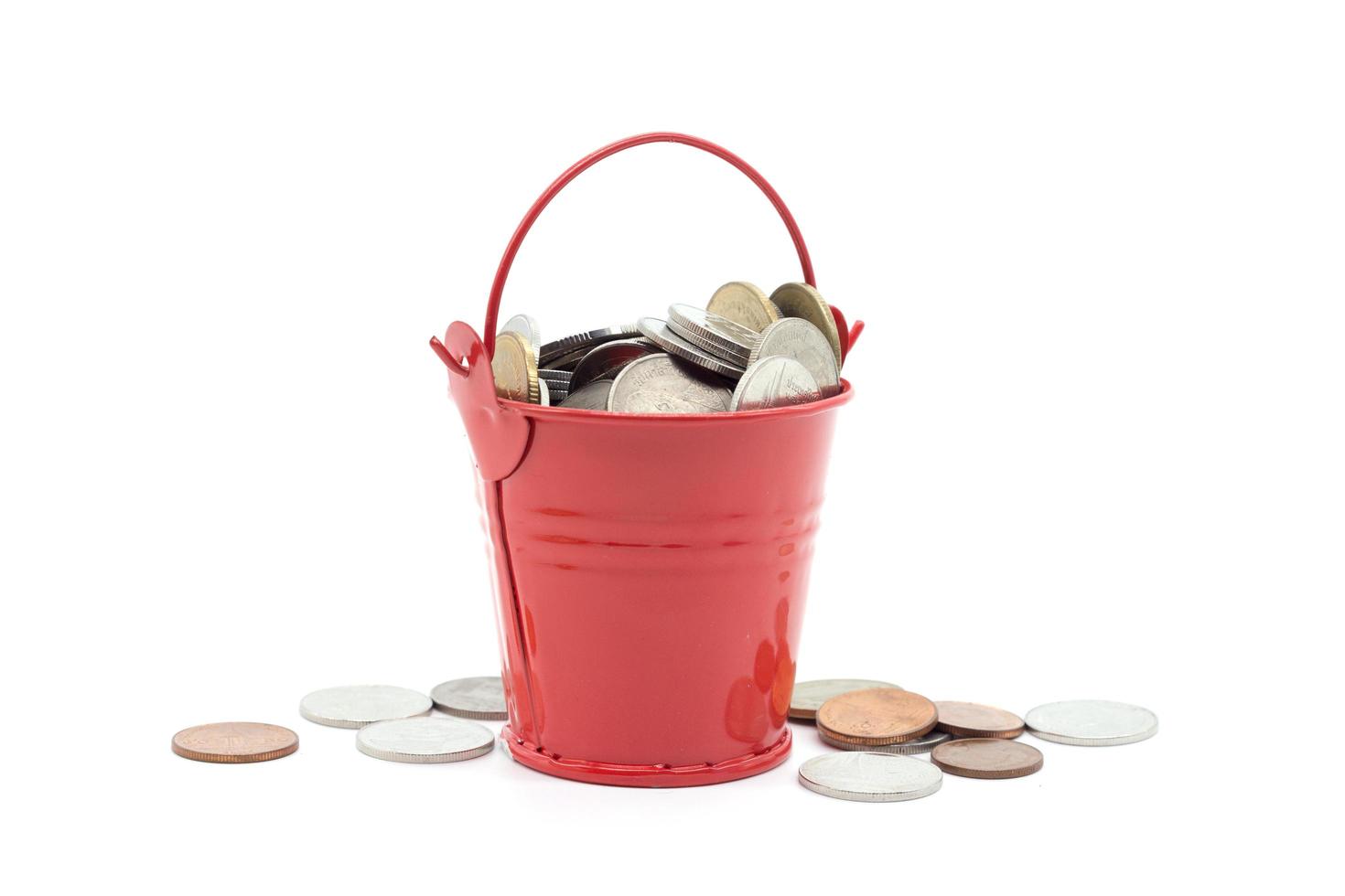 Small red bucket full of money on white background photo