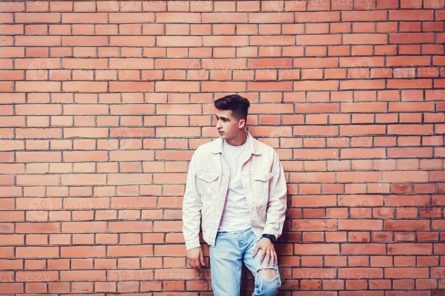 Stylish sexy man posing near brick photo