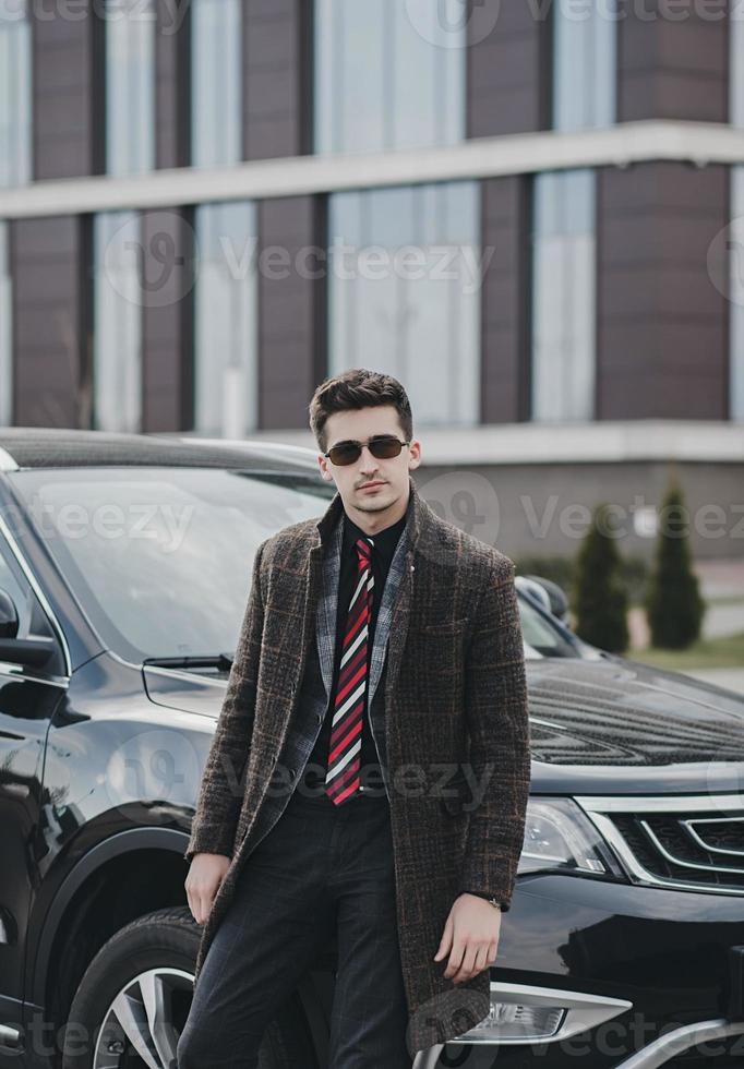 businessman in a business suit near his car photo