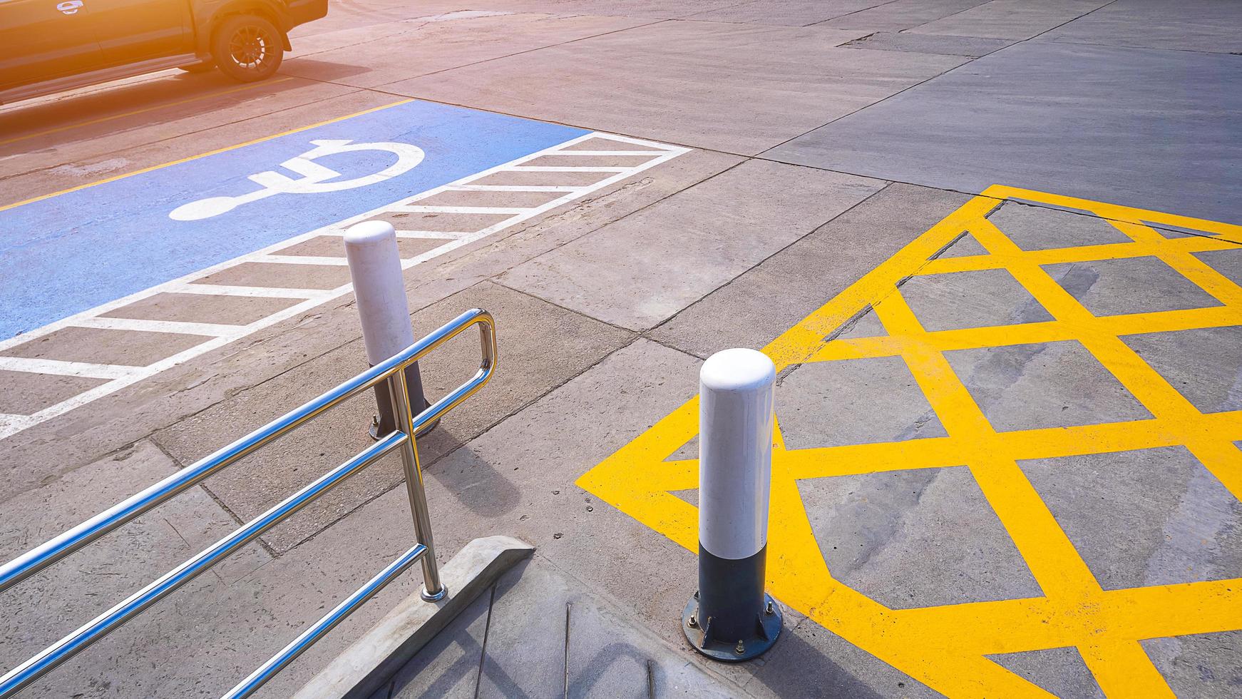 no hay señal de estacionamiento con silla de ruedas para discapacitados y barandilla en la superficie del suelo de hormigón en el estacionamiento del área de baños públicos en la gasolinera foto
