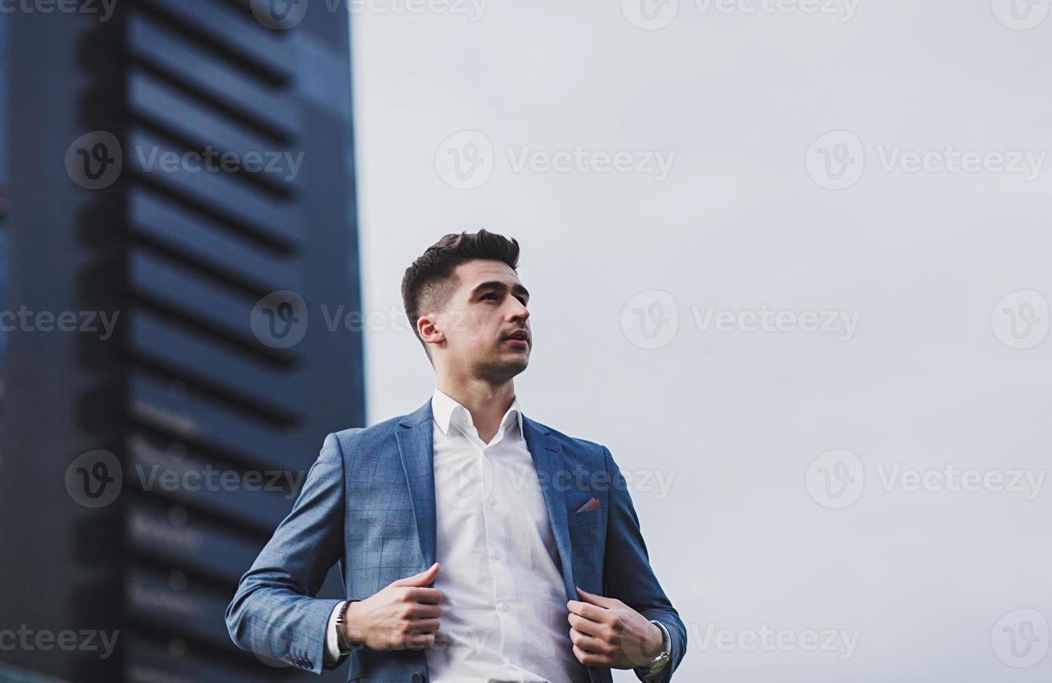 man in suit against office building photo