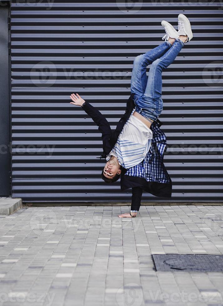 Young funky man standing on one hand photo