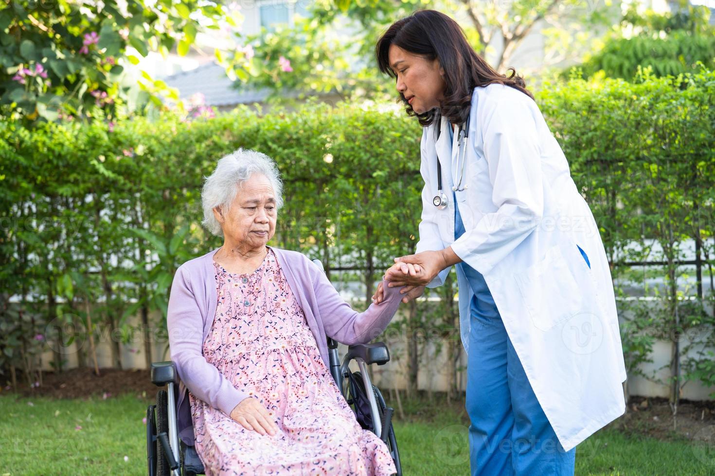 Médico ayuda y cuidado paciente asiático mayor o anciana mujer sentada en silla de ruedas en la sala del hospital de enfermería, concepto médico fuerte y saludable foto