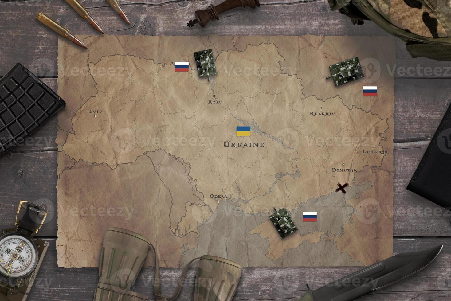 Map of the Russian invasion of Ukraine with military equipment on the table. Top view, flat lay concept composition photo