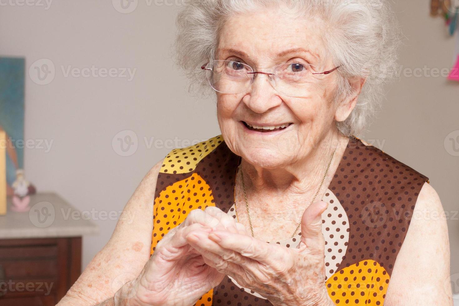 anciana en casa inspeccionando sus manos secas foto