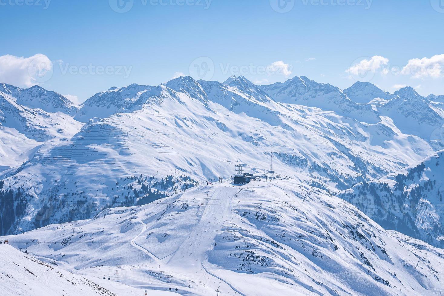 Aerial view of skiers and ski lift on snow covered mountain slope photo