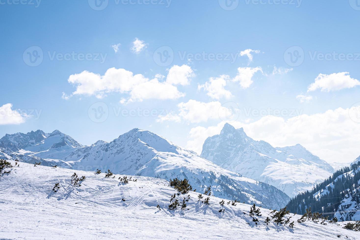 Ski tracks on snow covered mountain range slope photo
