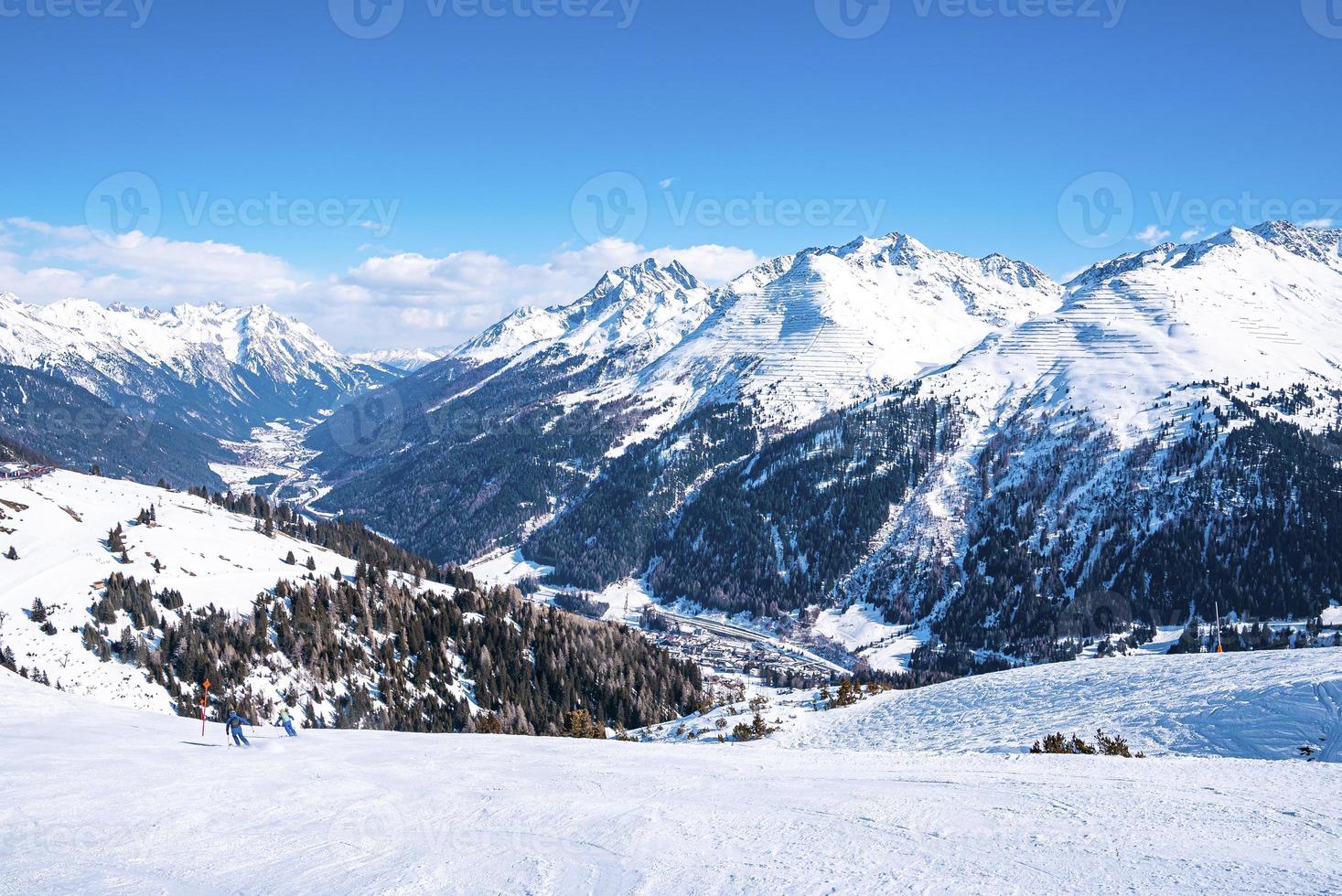 idílicas montañas cubiertas de nieve con un denso bosque contra el cielo en los alpes foto