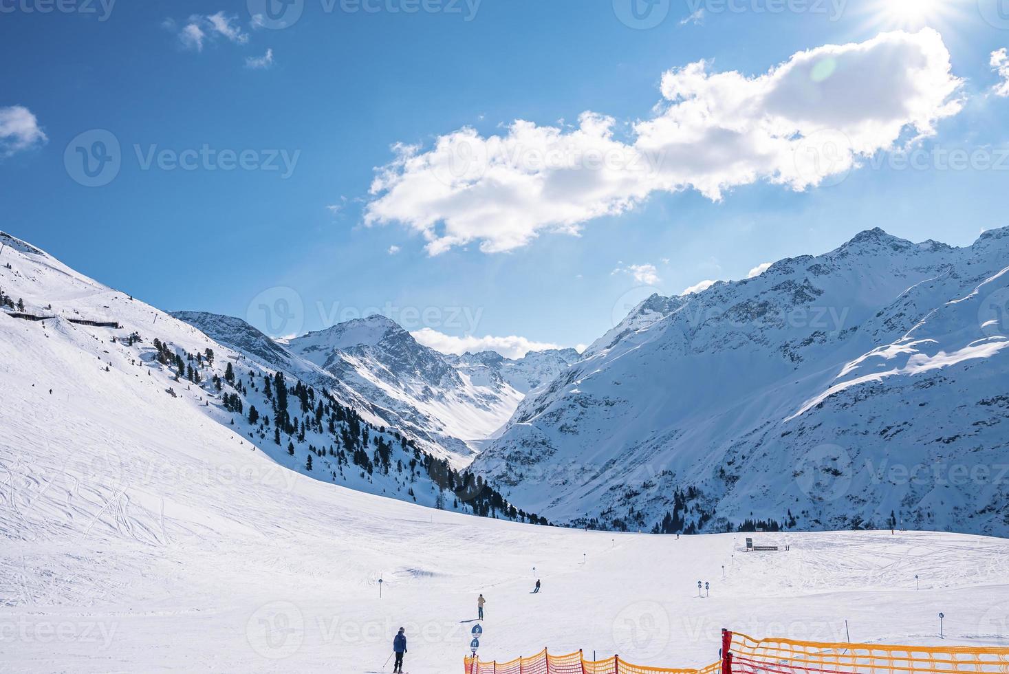 Skier skiing on snow covered mountain against sky photo