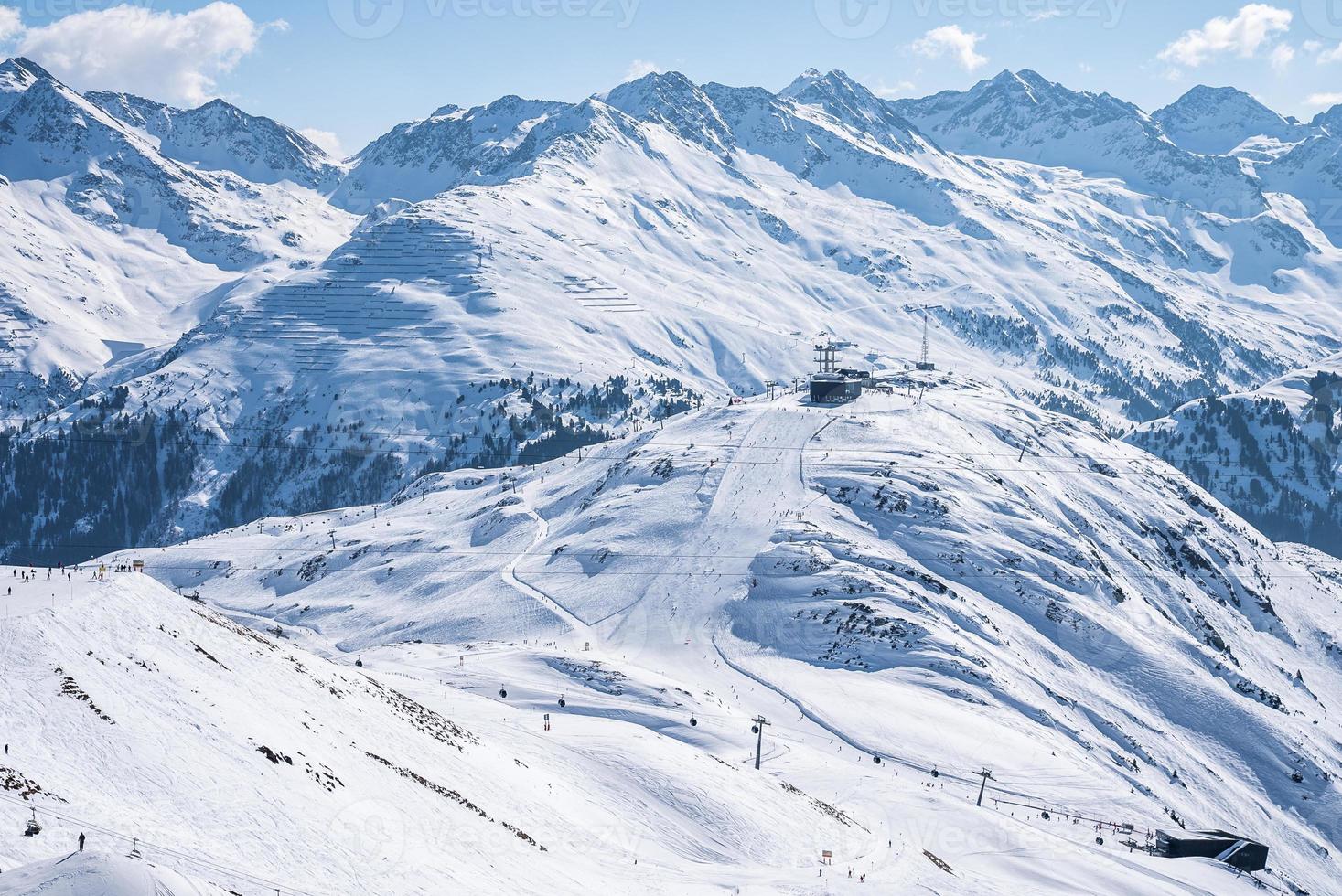 vista aérea del remonte y los esquiadores en la ladera de una colina cubierta de nieve foto