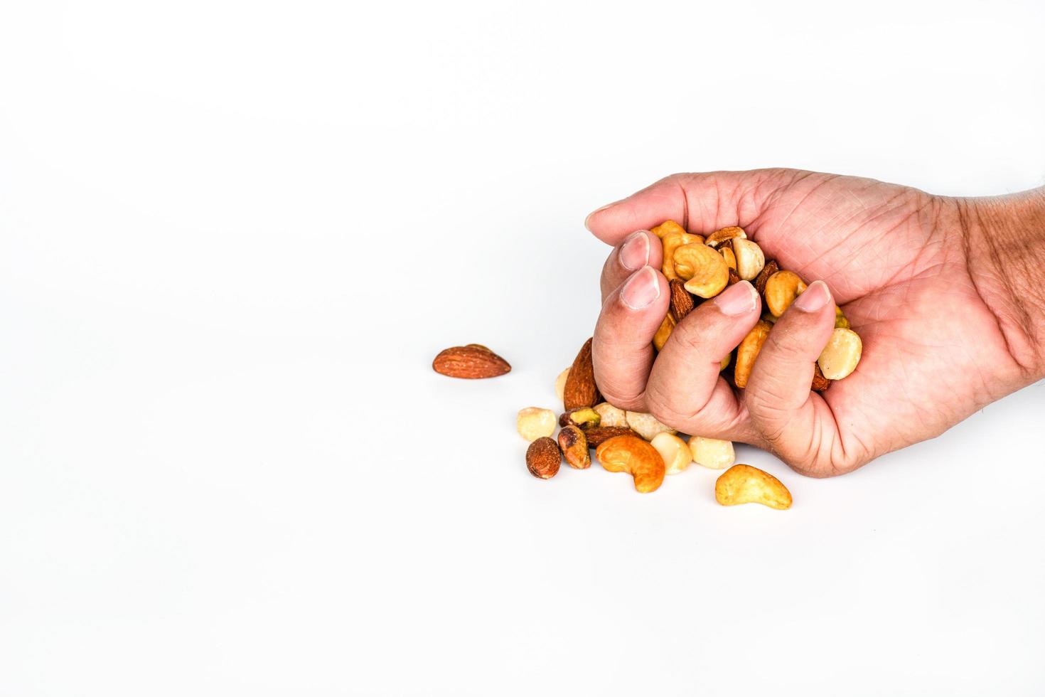 Concept, trail mix day. handful men trail mix on white background. closeup. copy space on left for design or text. photo