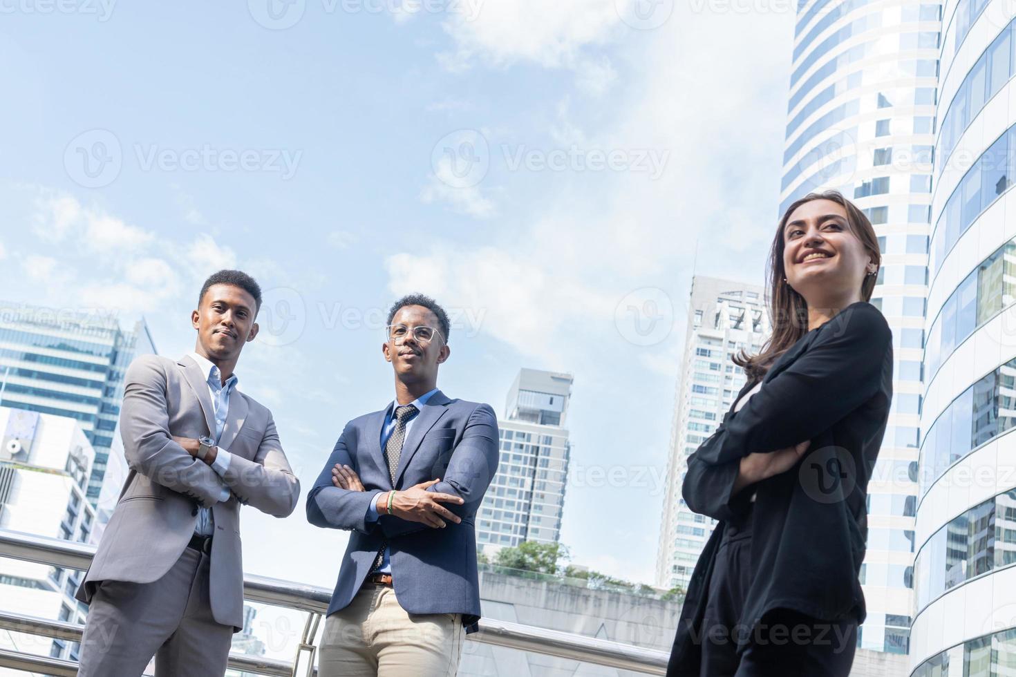 grupo de gente de negocios. gente de negocios reunida hablando y compartiendo sus ideas en la ciudad. equipo de negocios y concepto de trabajo en equipo. empresarios parados afuera en la ciudad discutiendo sobre un nuevo proyecto. foto