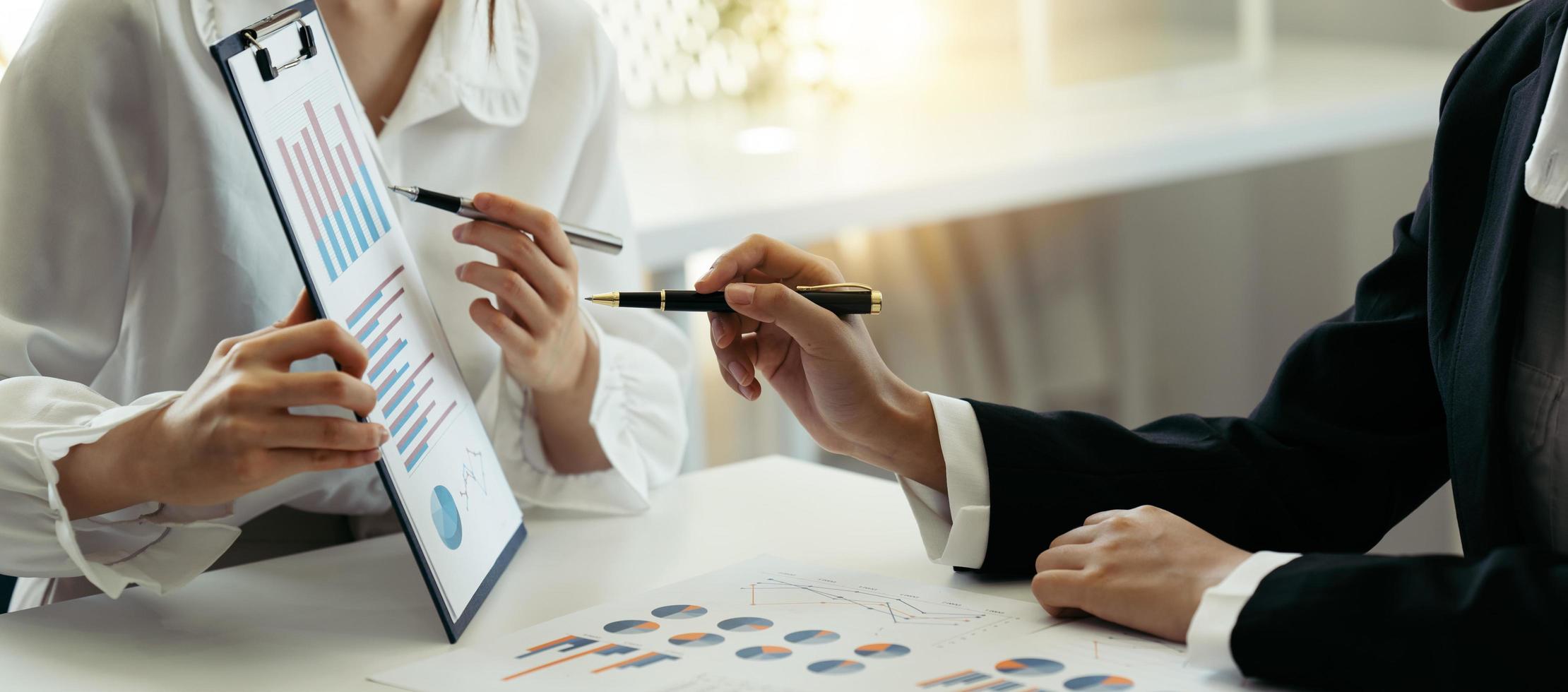 grupo de empresarios reunidos apuntando al gráfico para evaluar los beneficios empresariales. foto