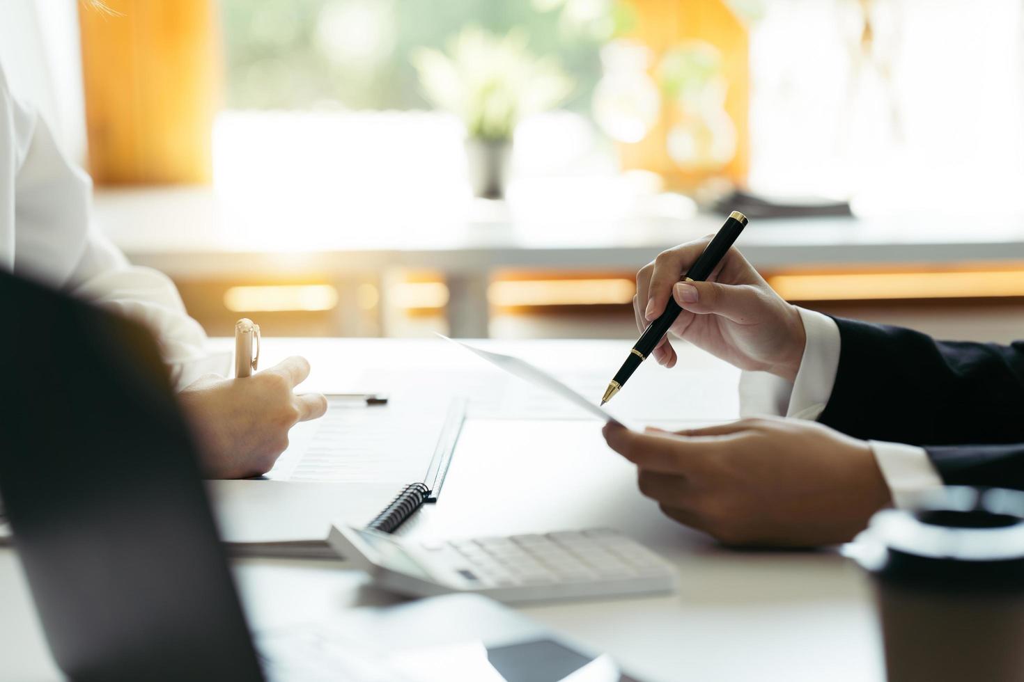 Financial adviser working with client, calculating and analyzing data at the table in office. photo