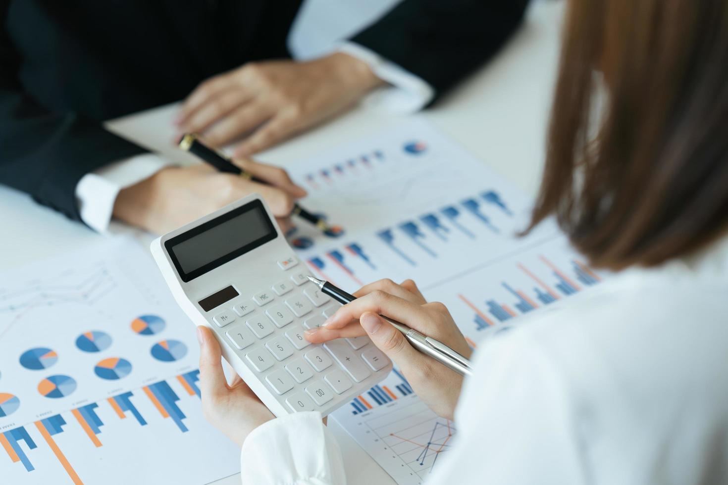 Financial adviser working with client, calculating and analyzing data at the table in office. photo