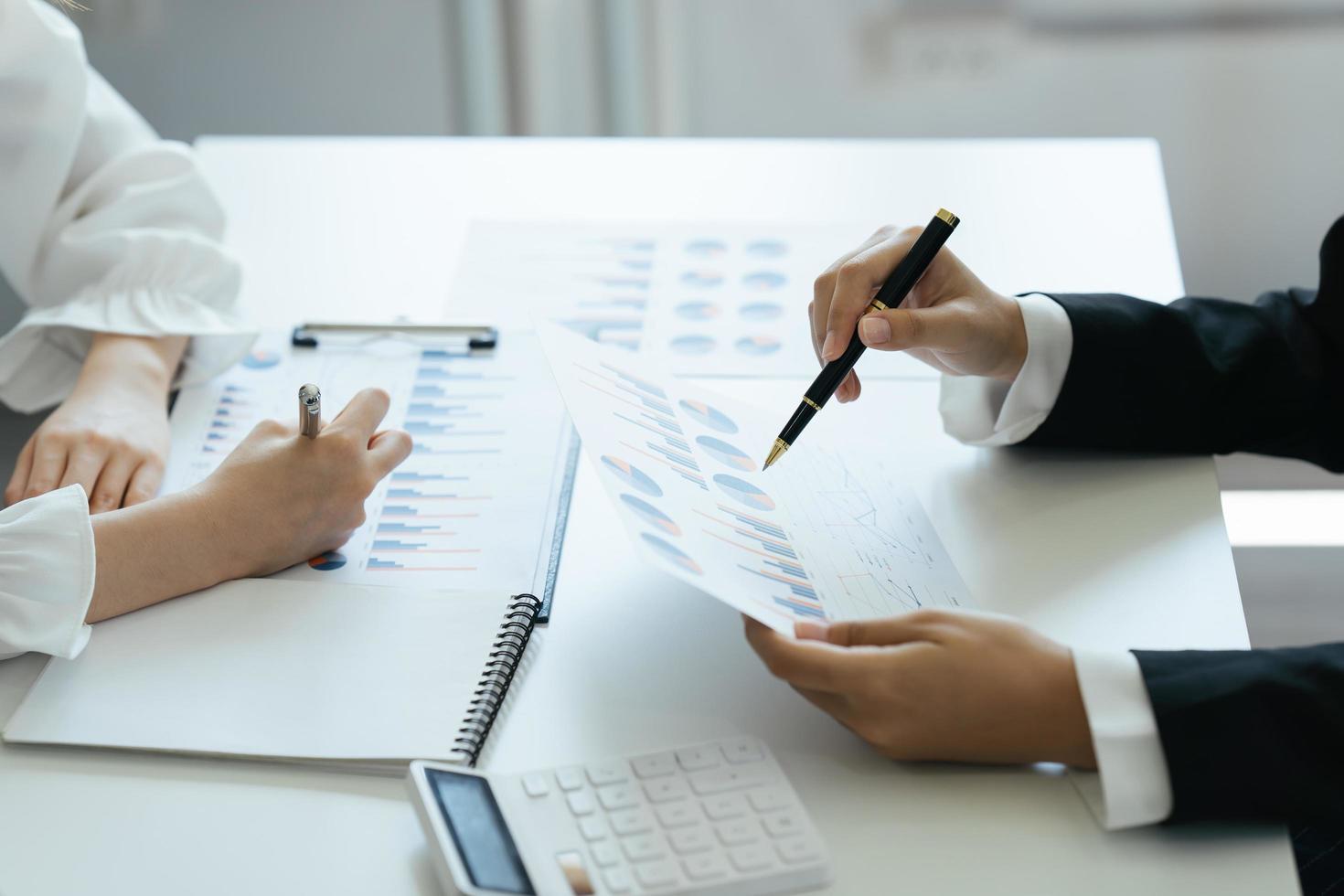 compañeros de trabajo de la asociación comercial que utilizan un informe para analizar el informe del presupuesto financiero de la empresa y el progreso del trabajo de costos y la planificación para el futuro en la sala de la oficina. foto