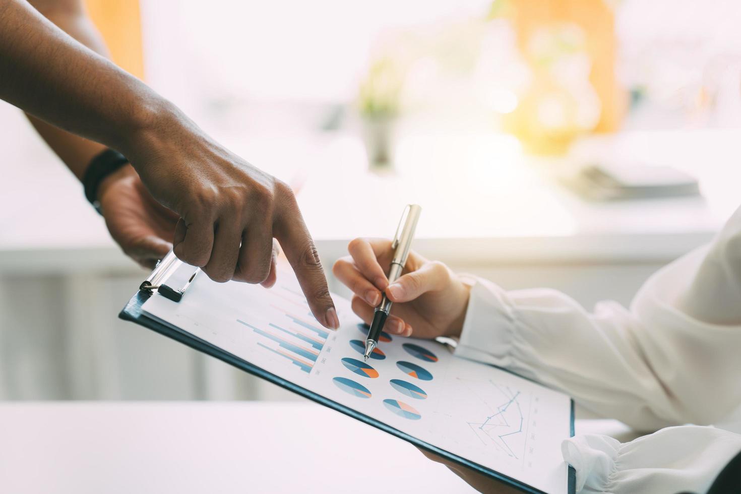 grupo de empresarios reunidos apuntando al gráfico para evaluar los beneficios empresariales. foto