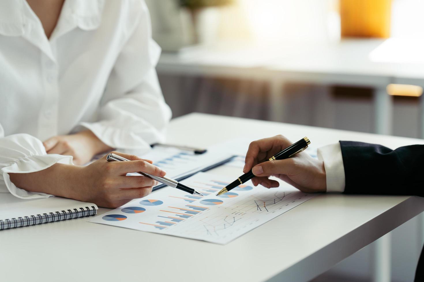 Financial adviser working with client, calculating and analyzing data at the table in office. photo