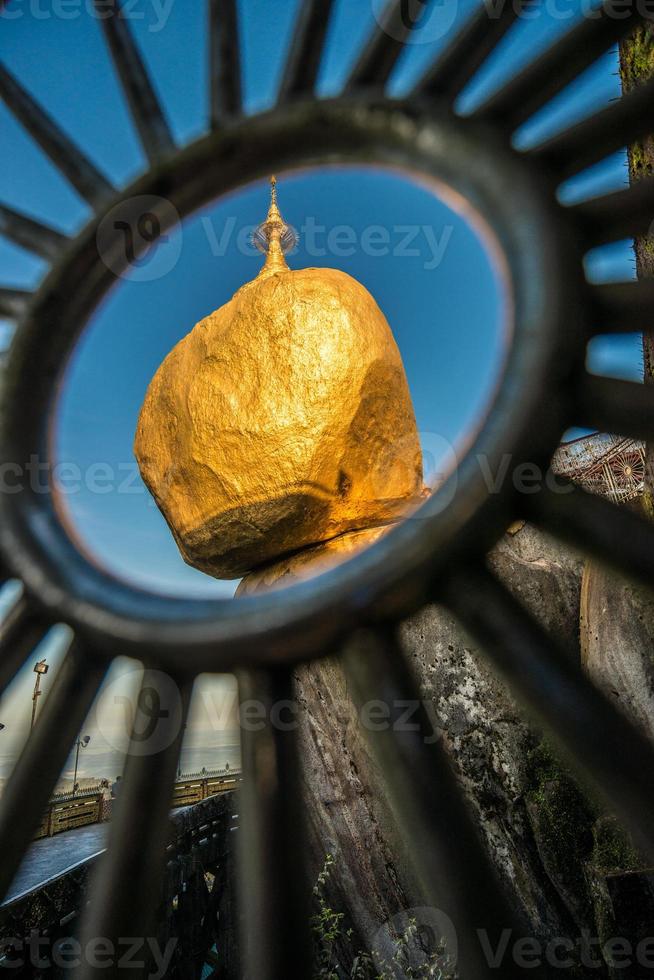 The golden rock pagoda or Kyaikhtiyo pagoda an iconic popular place in Mon state in Myanmar. View look through the fence. photo