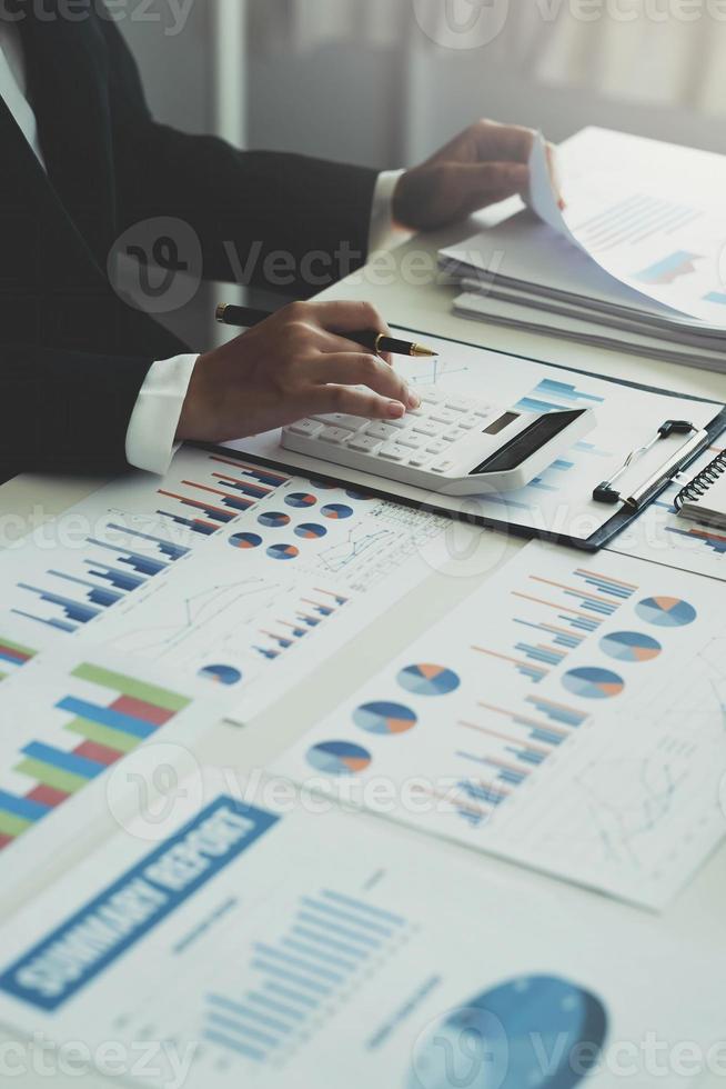 businesswoman working on desk office with using a calculator to calculate the numbers, finance accounting concept photo