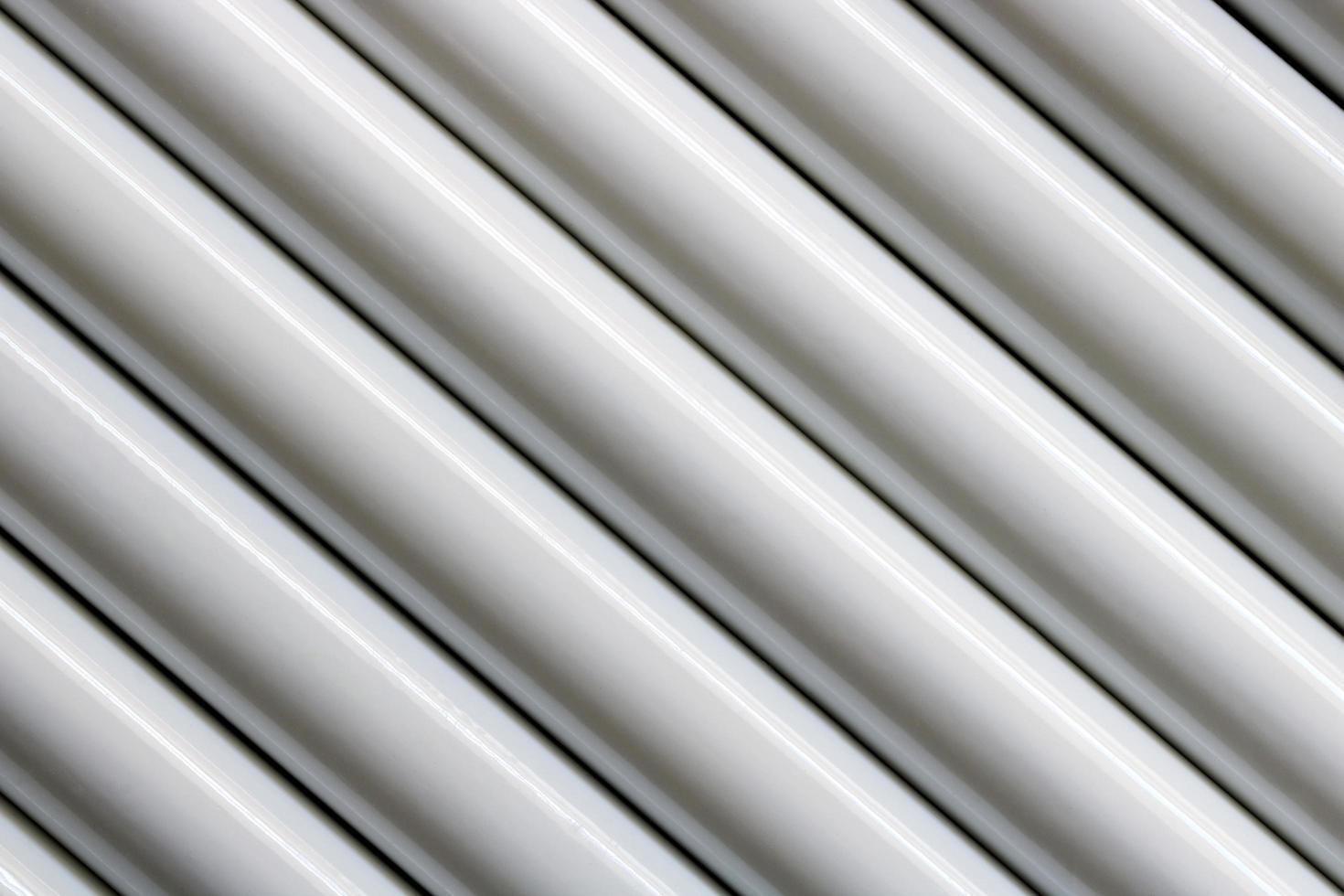 Texture of white steel pipe sort in diagonal, abstract background photo