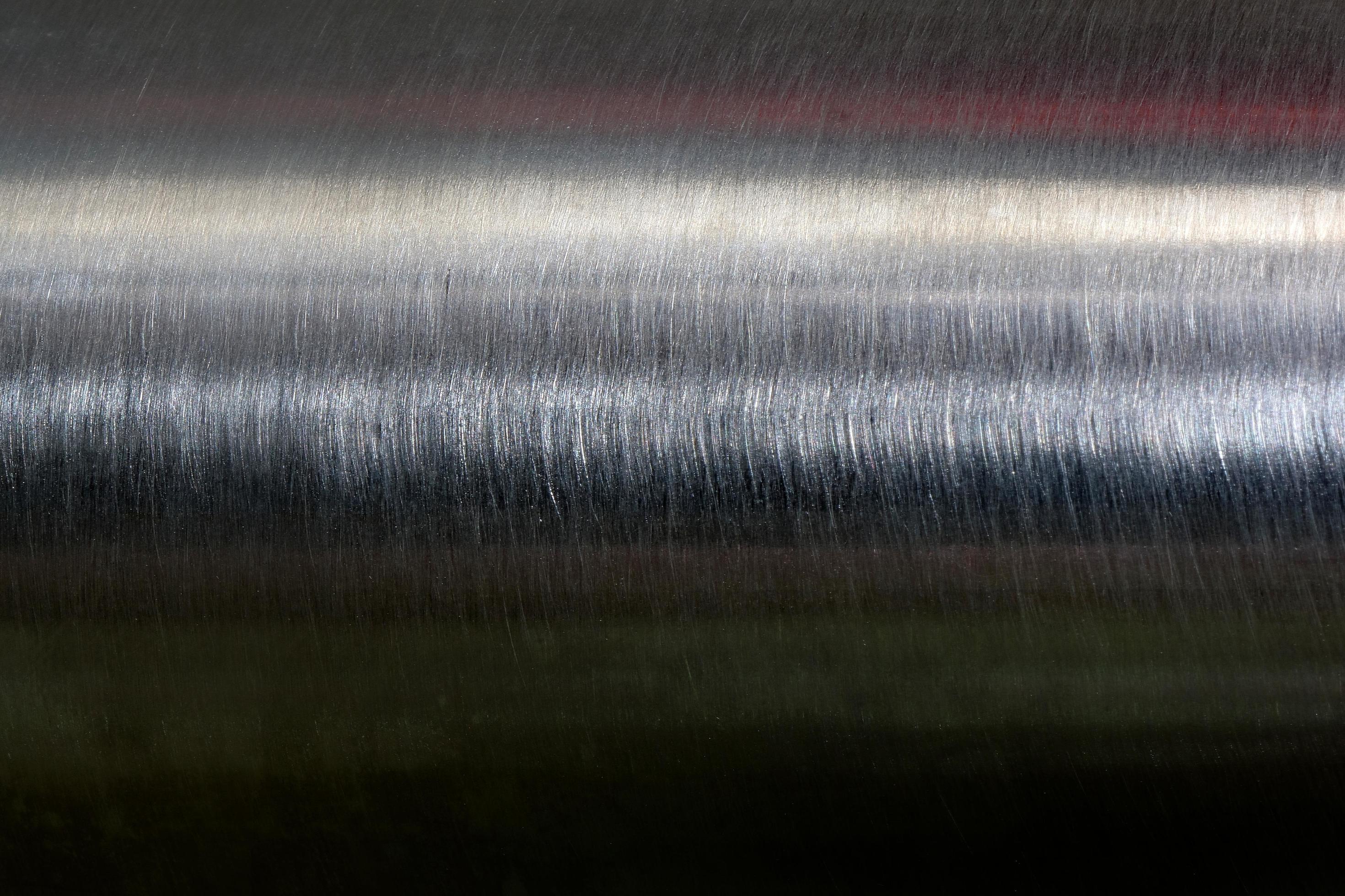 Texture of reflection on stainless steel pipe in dark room, abstract