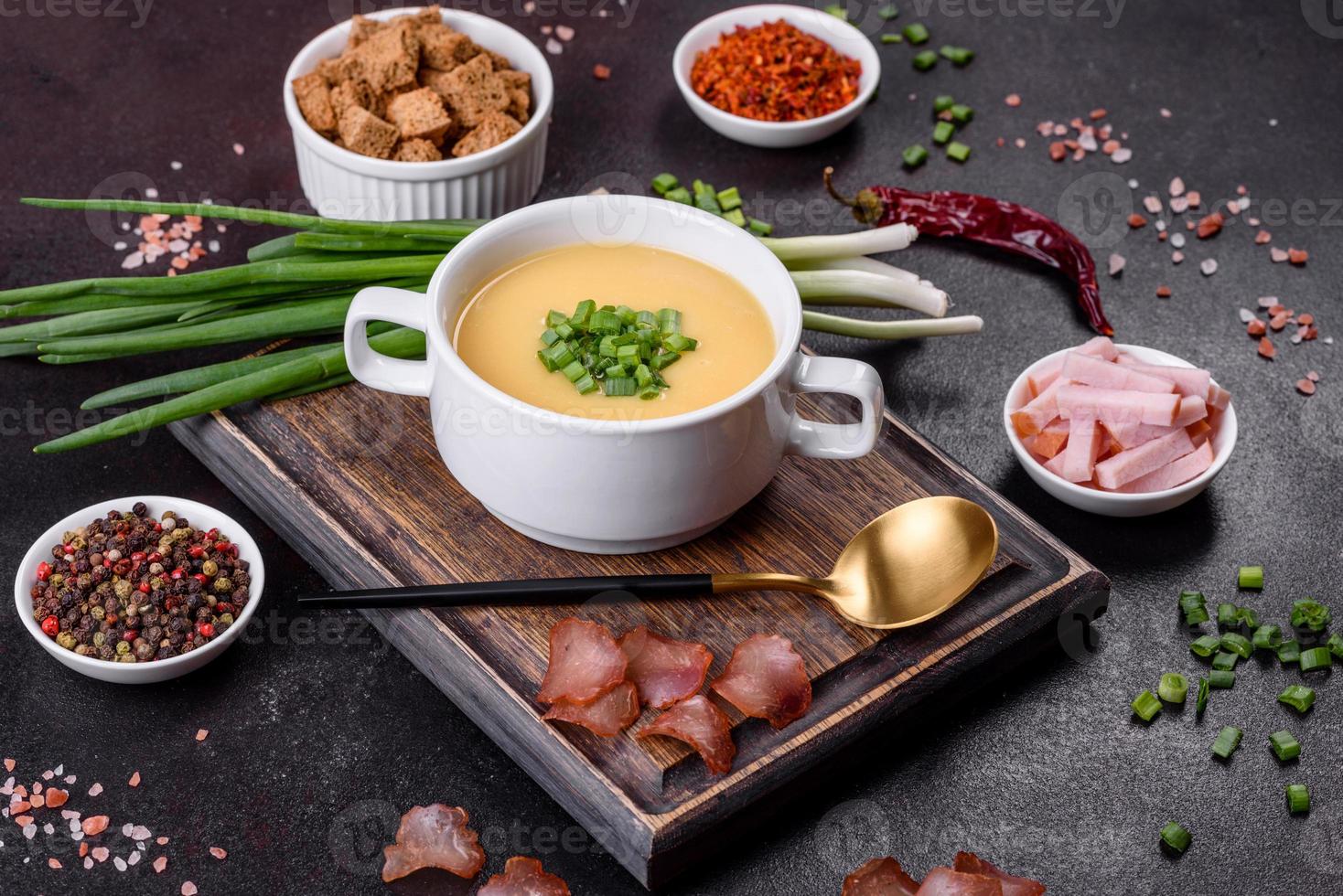 sopa de crema con patatas, puerros y guisantes sobre una mesa de hormigón oscuro foto