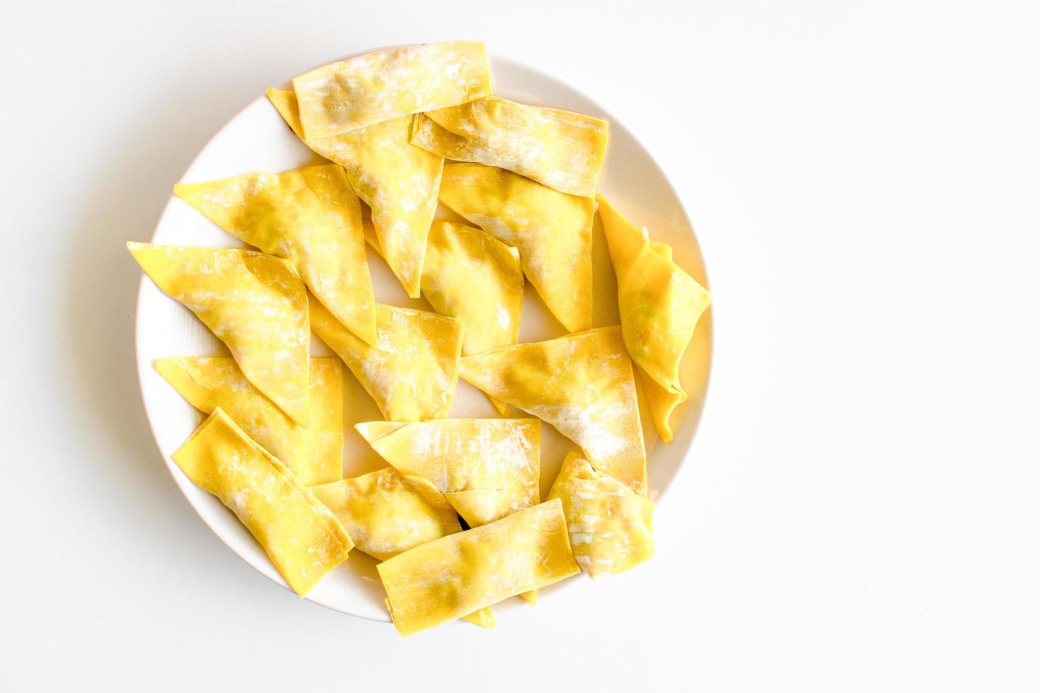 The yellow food is sliced on a white plate and placed on a white-ground table. Closeup, copy space on right for design or text, white background photo