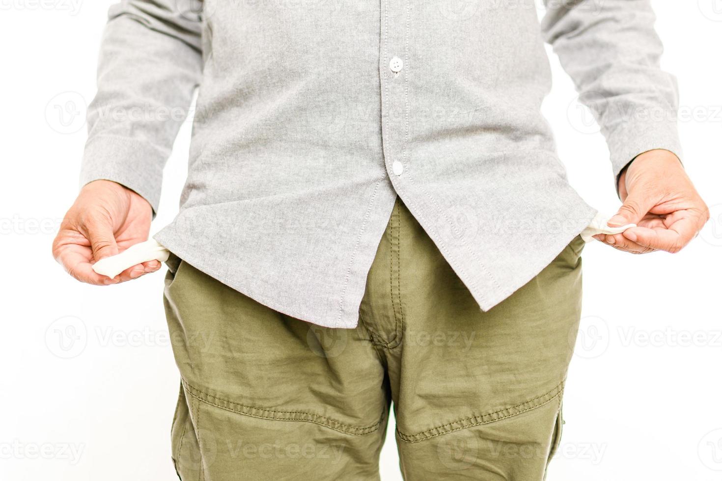 Asian men show no money in their trouser pocket. the concept for recession, bankrupt, bankruptcy, sad, crisis, stress, unhappy. Selective focus, closeup, white blur background photo