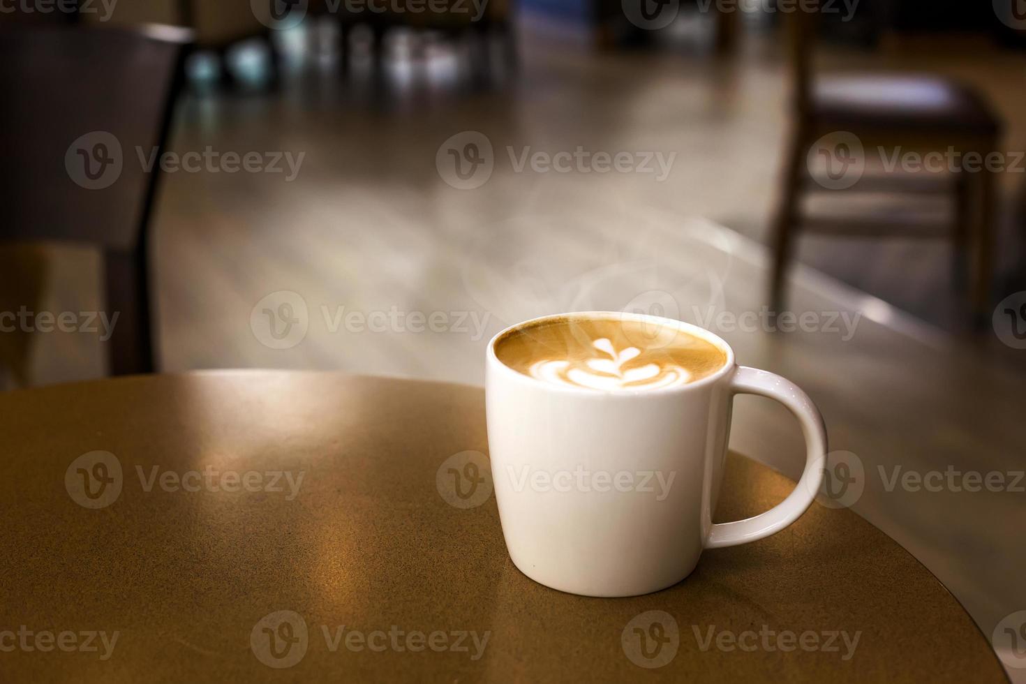 taza de café caliente con humo en la mesa de madera vacía foto