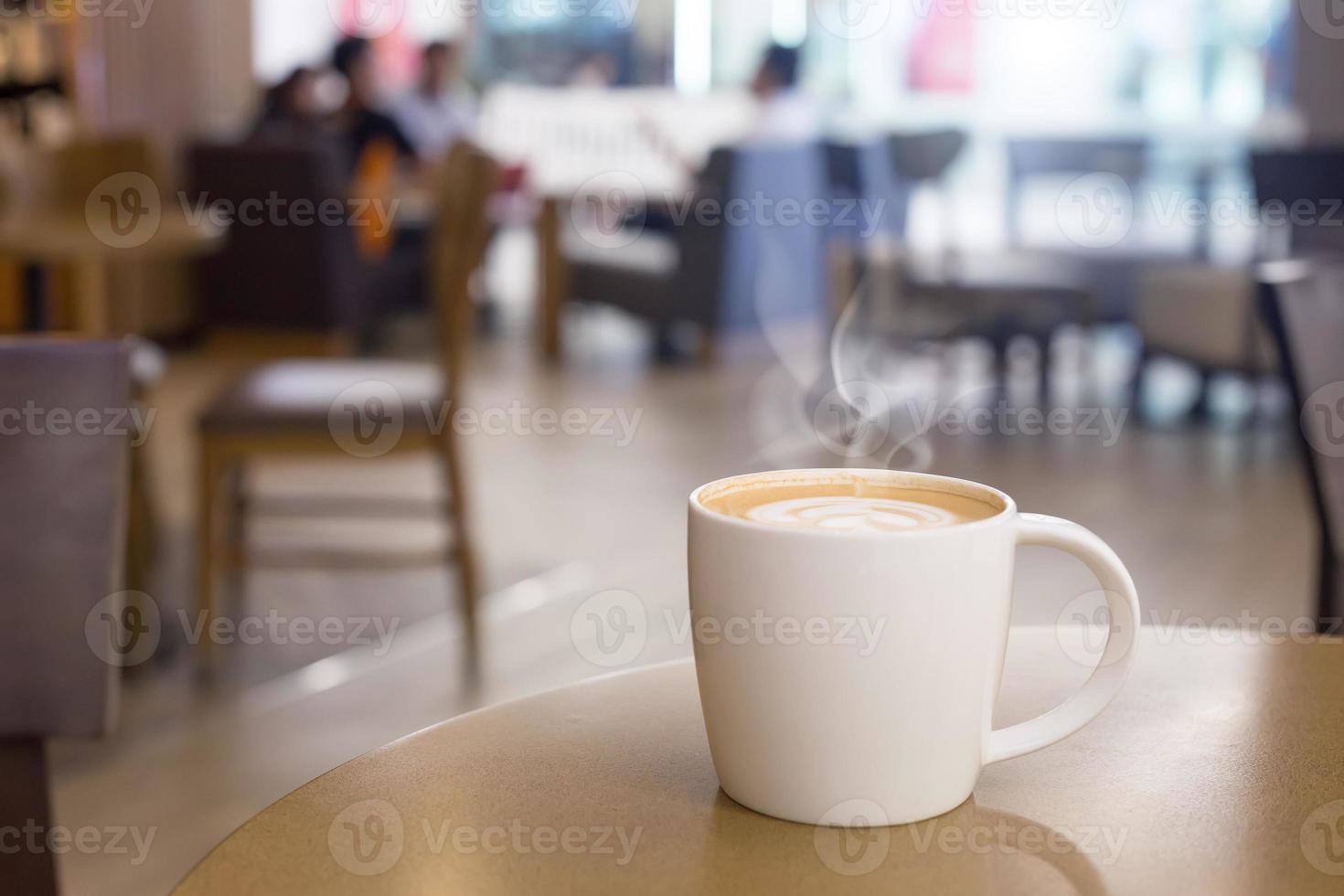 taza de café caliente con humo en la mesa de madera vacía foto