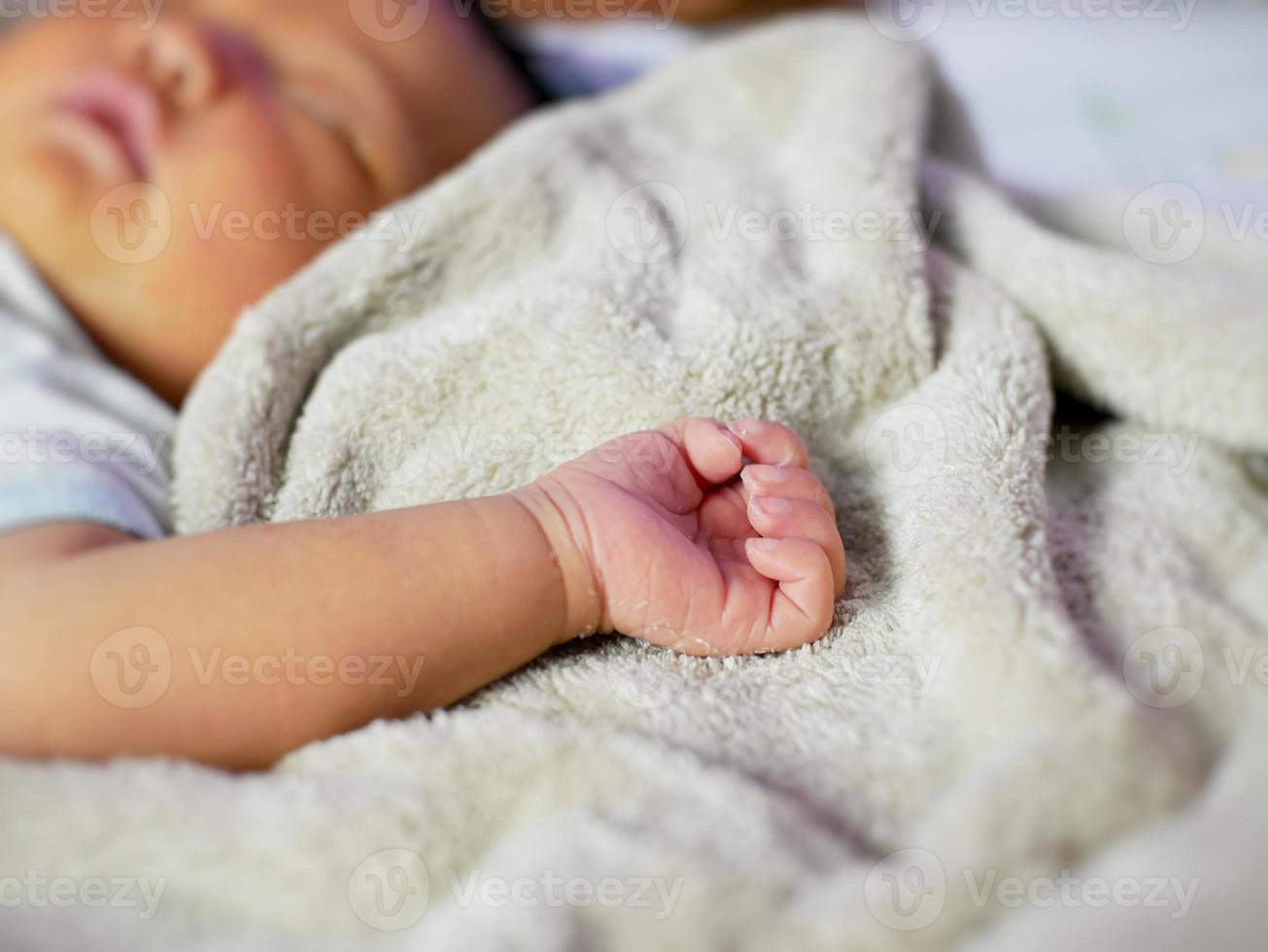 la mano del bebé está durmiendo en la manta. los recién nacidos se sienten seguros y cálidos. enfoque suave selectivo. foto