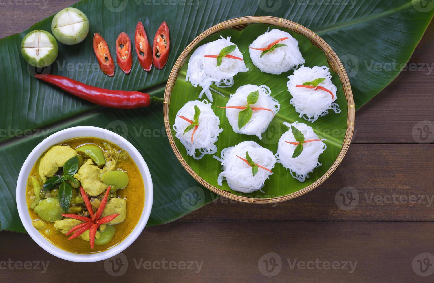 Top view of rice noodles with chicken green curry on wooden table decorations in vintage tone style photo