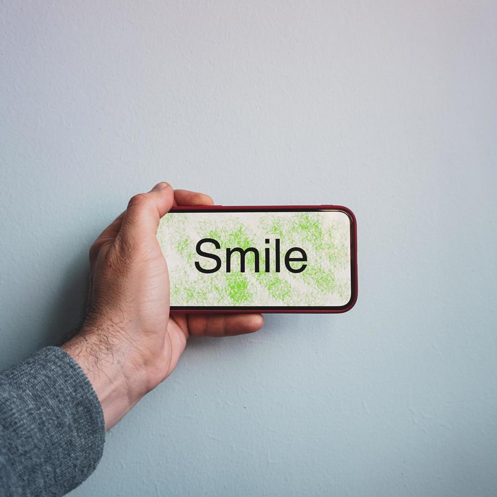 word smile on the smartphone, feelings and emotions photo