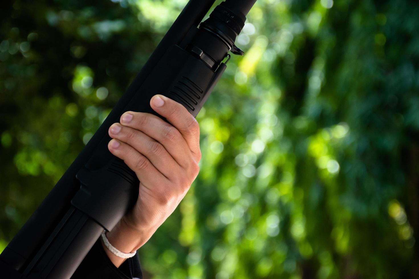 Asian young boy holds shotgun in hands, soft and selective focus on hands. photo
