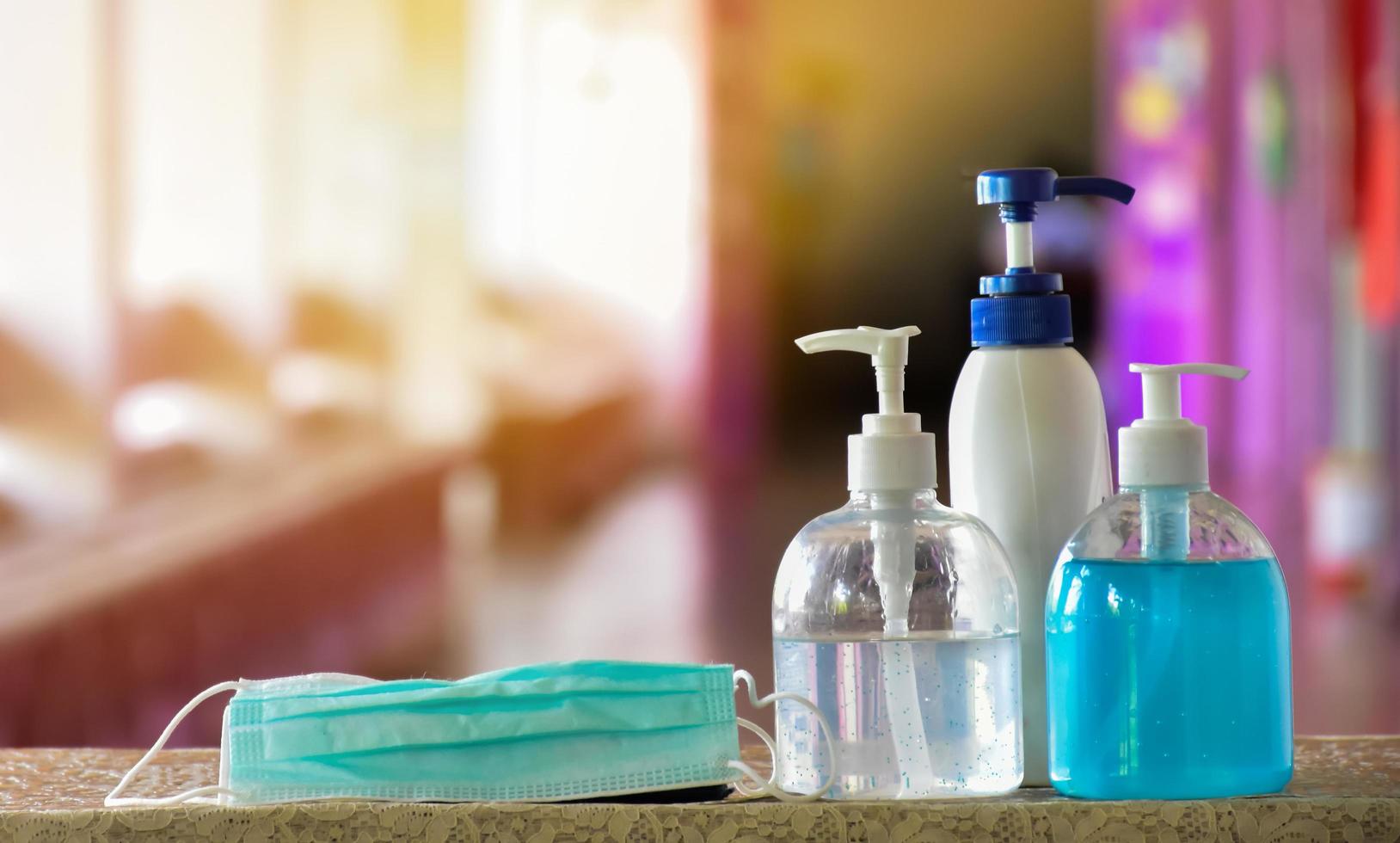 Hand sanitizer gel and facemasks to clean hands and wear before getting inside to protect and prevent Covid-19 virus or Coronavirus and germs. photo
