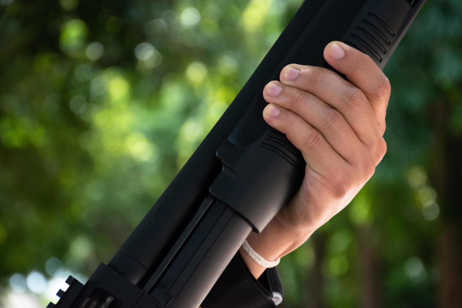 Asian young boy holds shotgun in hands, soft and selective focus on hands. photo